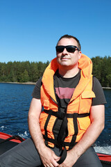 Man posing in life jacket on boat