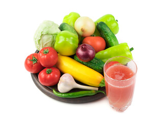 A glass of fresh vegetable juice and a Large selection of fresh vegetables on a round tray on a white background. Plant background. The concept of proper nutrition.