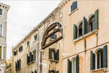 Naklejka premium Beautiful view of Traditional Venetian buildings along a water channel, Venice, Italy, Europe.
