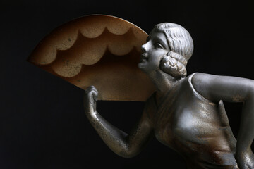 Ritratto di una giovane, elegante donna con ventaglio. Primo piano di scultura in metallo, tipico...