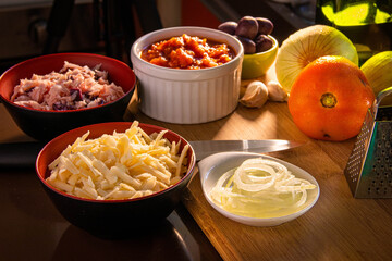 Bowls of pizza toppings in a kitchen