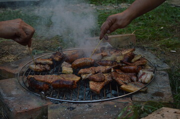 A fire built on bricks is a homemade barbecue grill. Summer picnic.
The meat is cooked over a fire. Barbecue made of bricks.
