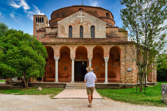 Man standing in front of Church of Santa Fosca, Torcello, Venice, Veneto, Italy