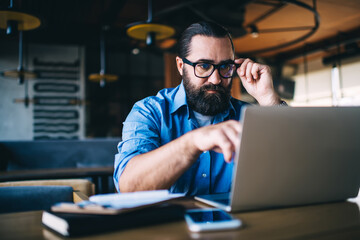 Focused adult man using laptop for work