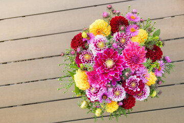 Fototapeta na wymiar Elegant autumn bouquet or composition of flowers of dahlias, New England asters, red, purple and yellow shades or warm tones. Composition for Thanksgiving, anniversary, teacher's day, birthday