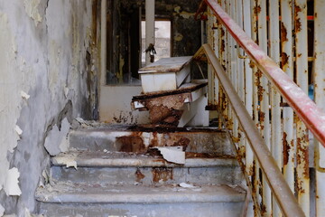 Old decaying furniture on a dilapidated rusting staircase.