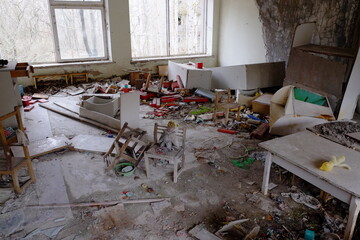 Scattered furniture and toys in an abandoned kindergarten in Pripyat. Mess and rubbish in the room. An abandoned building in the Chernobyl resettlement zone.