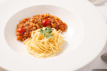 meat pork spaghetti tomato sauce in white round dish decorate by white fabric stock photo