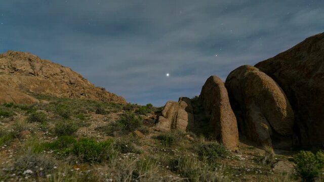  Astro timelapse tracking shot of Milky Way galaxy revealed as the moon sets behind Sierra Nevada mountains in Alabama Hills, California