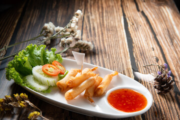 shrimp warp or ebi roll deep dry in white ellipse dish fill with spicy source decorate by slice...