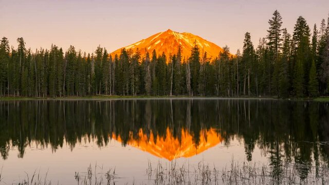  Time lapse of morning sun illuminating Lassen Peak at alpine lake in Lassen Volcanic National Park in California