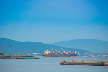 A cargo ship is parked on the sea at the port of transport.