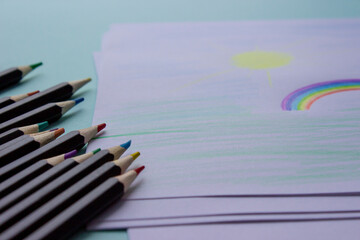 Multi-colored pencils lie on a light background. The pencils are in perfect order