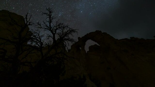  Time lapse tracking shot of starry sky over Grosvenor Arch at Grand Staircase Escalante National Monument in Utah