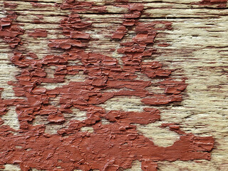 faded red paint on rough wood wall surface