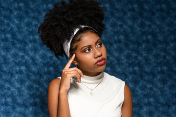 Afro-Brazilian teenager thoughtful in a distant blue background