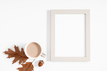 Autumn creative composition. Photo frame, dry leaves, cup of coffee white background. Fall concept....