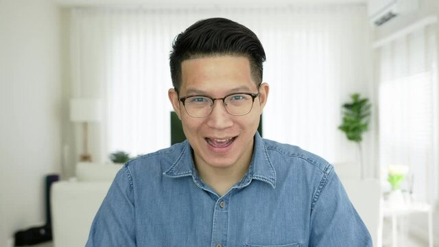 Confident asian man vlogger make live video conference call, chat online on computer and sitting on table at home, Webcam view, video chat, Work from home, Working remotely and Self isolation concept.