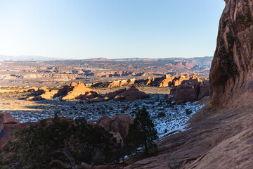 sun in the valley of a red rock desert in winter with snow on the ground