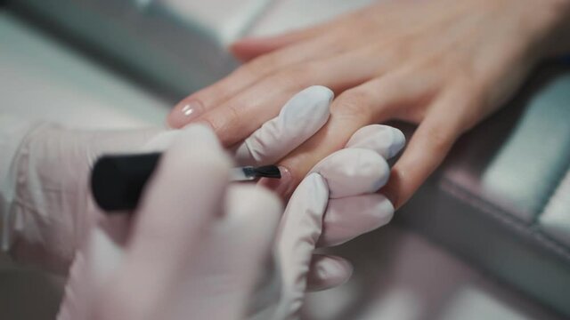 manicure artist making nail polishing with brush and tools