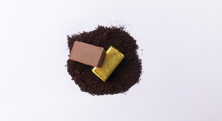 Close-up of a few ounces of chocolate on cocoa powder. On a white background