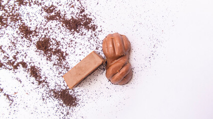 Close-up of a few ounces of chocolate on cocoa powder. On a white background