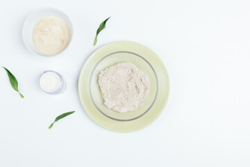 Natural homemade cosmetics, moisturizer cream and green leaves