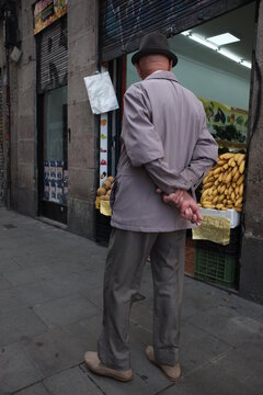 Anciano mirando puesto de frutas. 