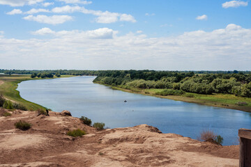 Blue river on a background of blue sky and green grass