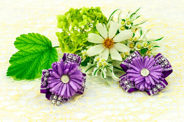 Barrette with elastic and violet ribbon, flowers and green leaf isolated on white background. - 376960948