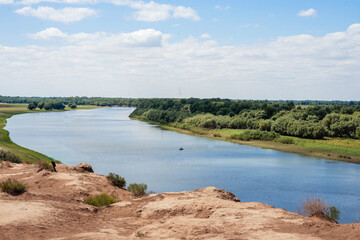 Blue river on a background of blue sky and green grass