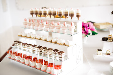 Delicious sweets on wedding candy buffet with desserts, cupcakes