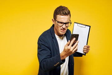 business man at work wearing glasses and a jacket on a yellow background talking on the phone employee model