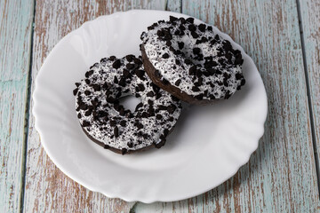 Donuts on a white plate on a wooden table