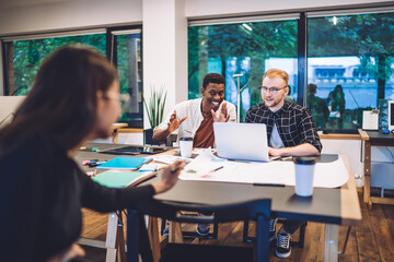 Cheerful diverse students making jokes during homework
