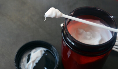 White thick cream on a cotton swab. Body and face care. Cosmetics.