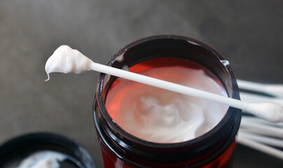 White thick cream on a cotton swab. Body and face care. Cosmetics.