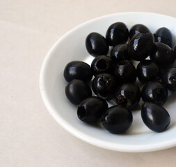 Pitted black olives on a white plate.