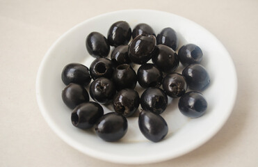 Pitted black olives on a white plate.