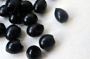 Pitted black olives on a white plate.