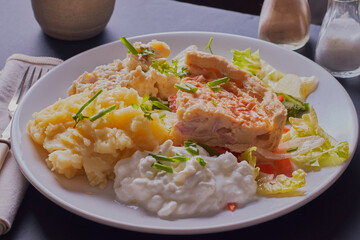 slice of quiche with salad and creamed potatoes.