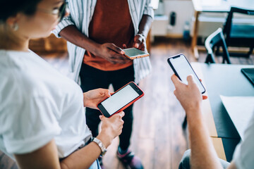 Faceless male surfing mobile doing project with coworkers in office