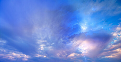 Obraz na płótnie Canvas Lightning strikes between blue stormy clouds