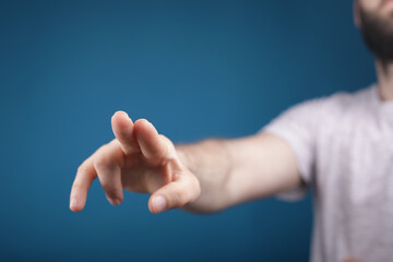 young man finger pointing touch blue background