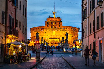 Castle of Holy Angel and Holy Angel Bridge over street in Rome at sunset.