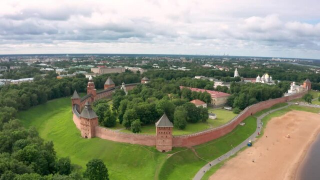 Panoramic aerial view of the Volkhov River and the old town of Veliky Novgorod, the red brick Kremlin in the rays of the setting sun and natural attractions of Russia.