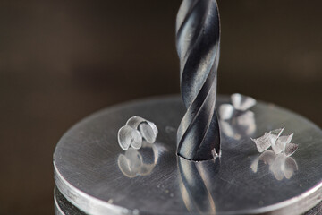 metal drill bit make holes in steel billet on industrial drilling machine. Metal work industry....