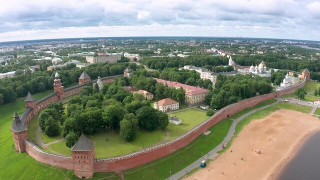 Panoramic aerial view of the Volkhov River and the old town of Veliky Novgorod, the red brick Kremlin in the rays of the setting sun and natural attractions of Russia.