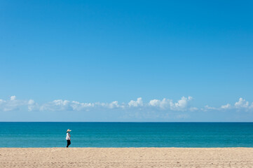 Fototapeta na wymiar Unrecognizable person walking on a totally empty beach