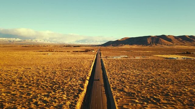 Long Desert Road with Car Traveling on Black Single Lane Road in Antelope Valley Palmdale Lancaster Southern California